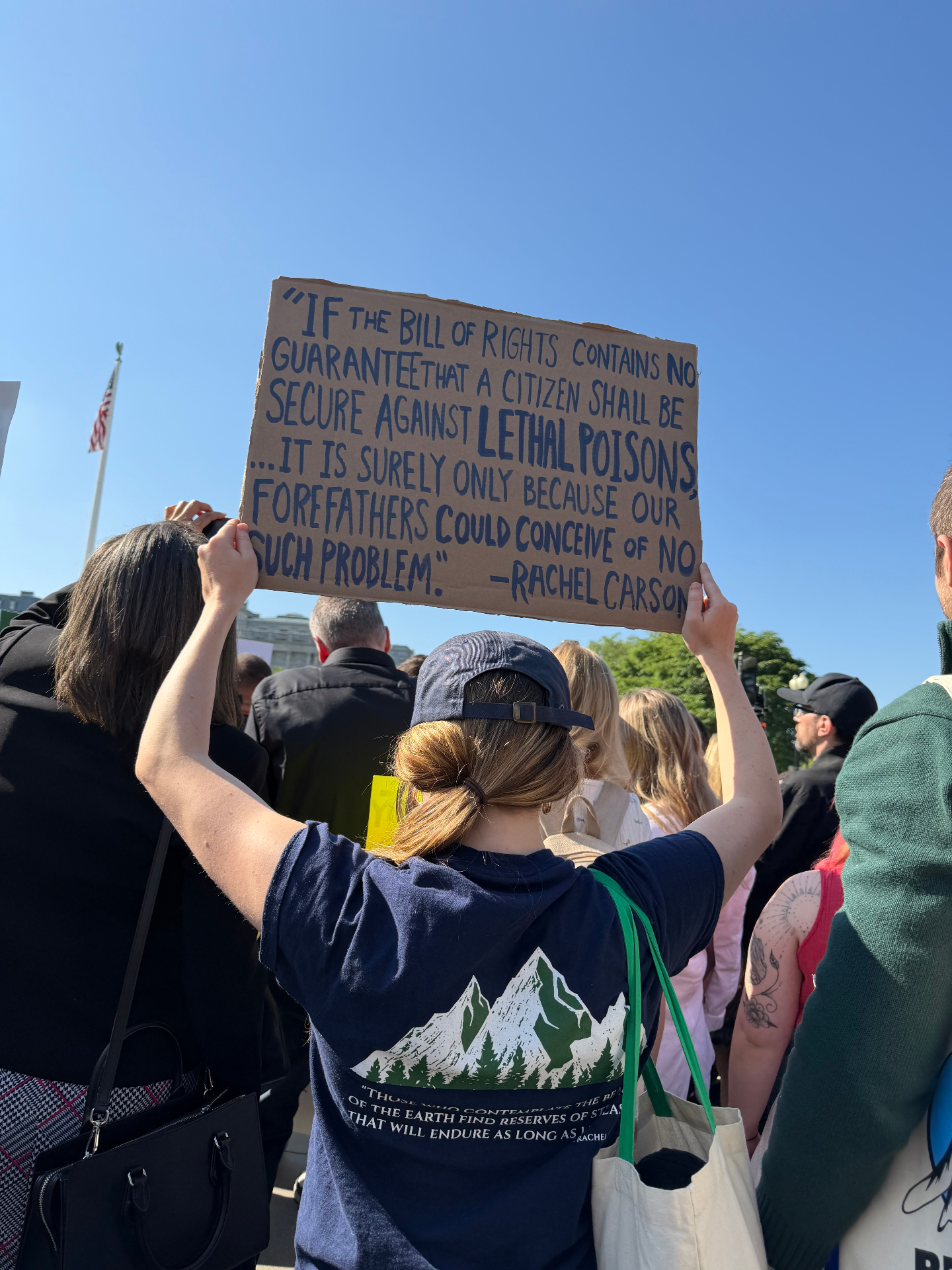 Protester holding a cardboard Rachel Carson quote about protection from lethal poisons